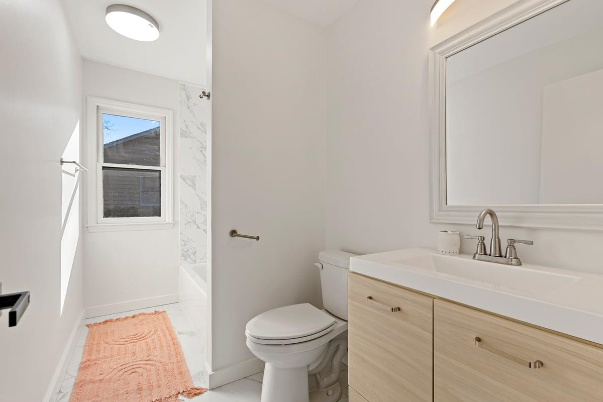 2718 Omah Street Durham, NC 27705 - Photo 13 of 20 a bathroom with a toilet sink and mirror