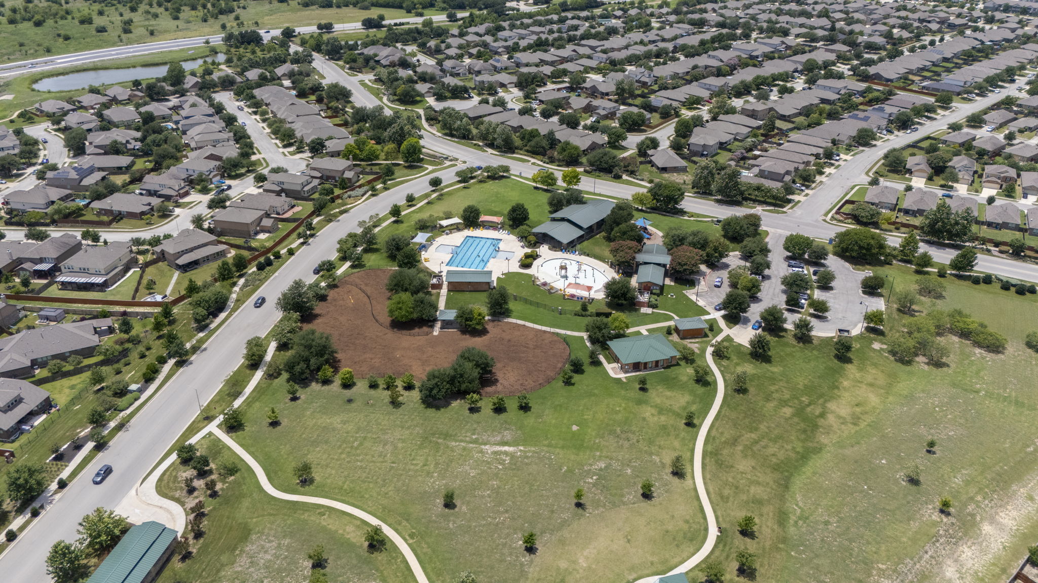 548 Purple Heart Drive Buda, TX 78610 - Photo 31 of 35 An aerial perspective reveals a vibrant community with recreational amenities and manicured green spaces.