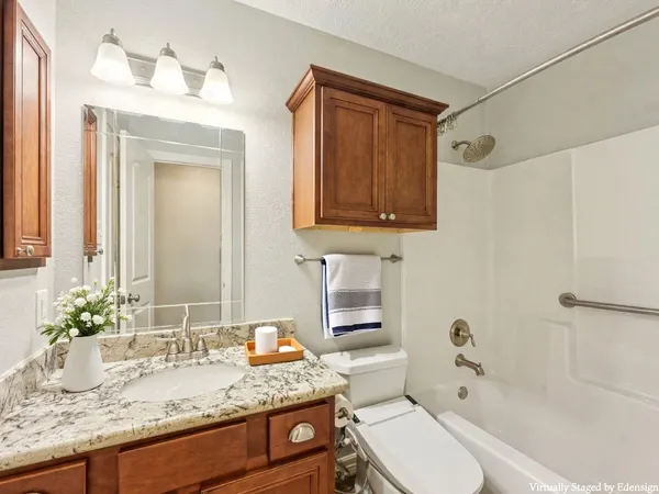 a bathroom with a granite countertop sink toilet and shower