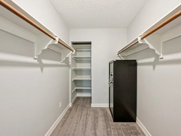 a view of walk in closet with empty racks