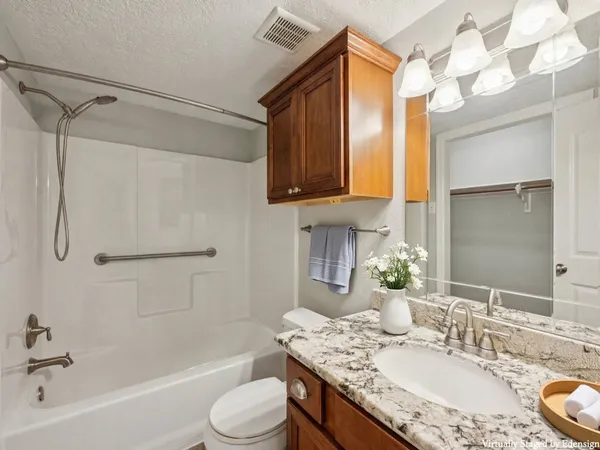 a bathroom with a granite countertop sink toilet and shower