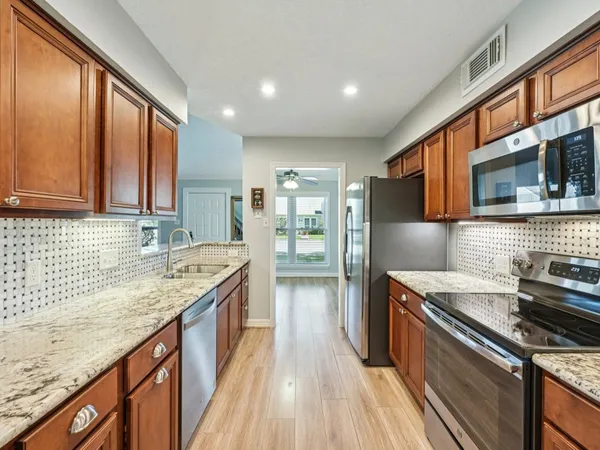 a kitchen with stainless steel appliances granite countertop a stove and a sink