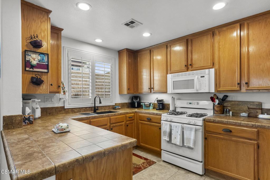 2046 Freesia Avenue Simi Valley, CA 93063 - Photo 16 of 37 a kitchen with a sink stove and cabinets