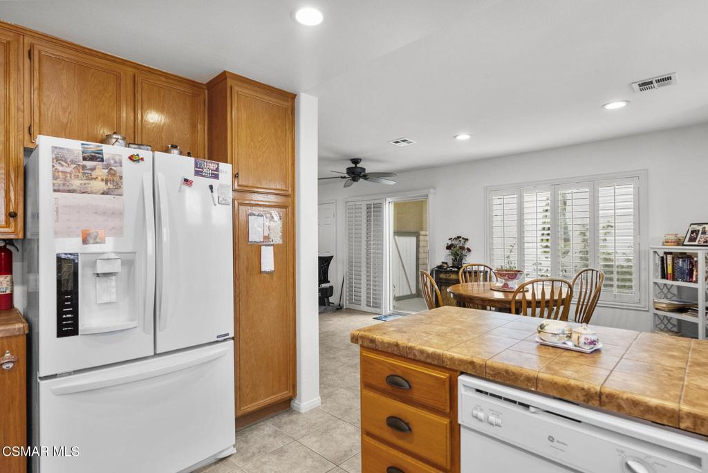 2046 Freesia Avenue Simi Valley, CA 93063 - Photo 18 of 37 a kitchen with stainless steel appliances granite countertop a refrigerator a sink a stove a dining table and chairs