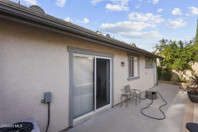 a backyard of a house with table and chairs