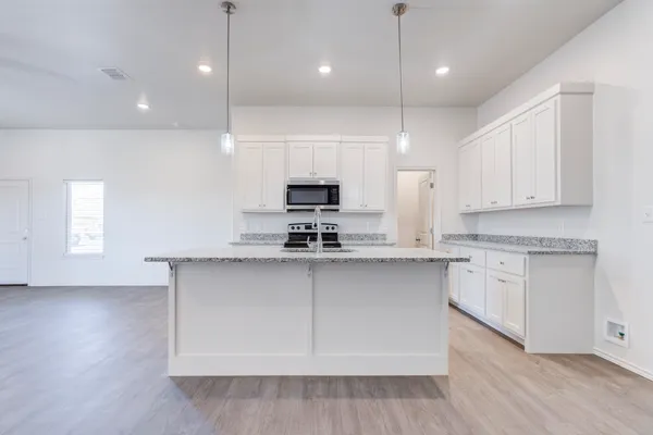 a kitchen with stainless steel appliances granite countertop a sink a stove and a microwave