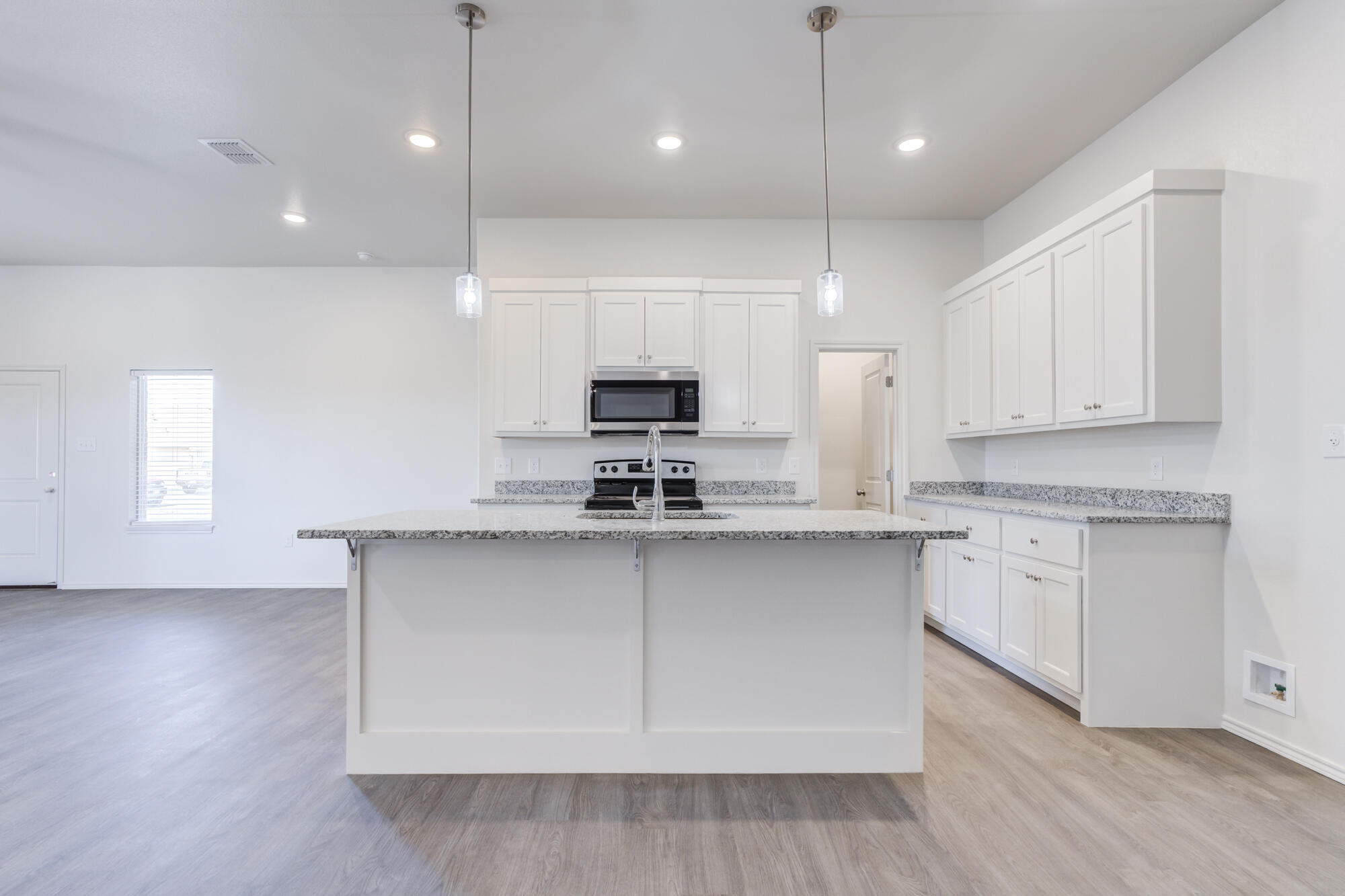 7011 40th Street Lubbock, TX 79407 - Photo 13 of 32 a kitchen with stainless steel appliances granite countertop a sink a stove and a microwave