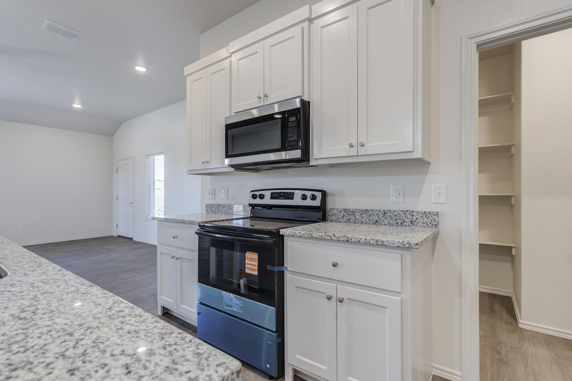 7011 40th Street Lubbock, TX 79407 - Photo 15 of 32 a kitchen with stainless steel appliances granite countertop a stove a sink and a microwave