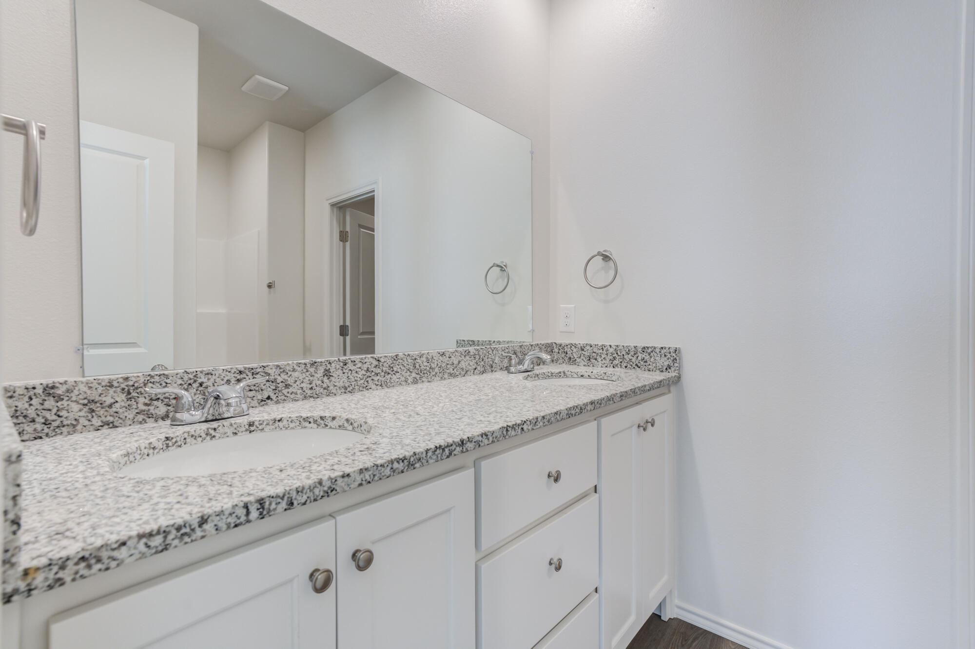 7011 40th Street Lubbock, TX 79407 - Photo 28 of 32 a bathroom with a granite countertop sink and white cabinets