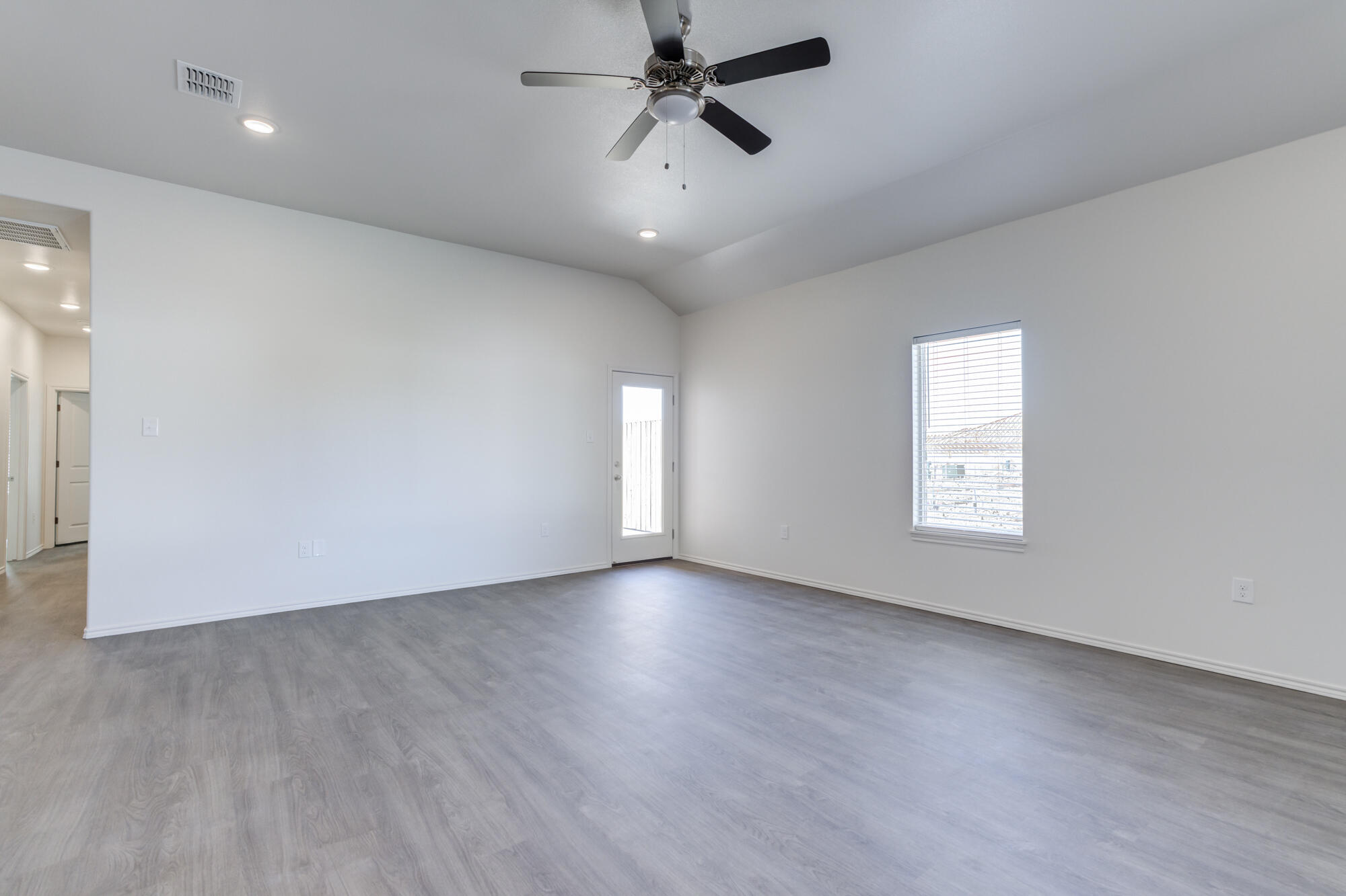 7011 40th Street Lubbock, TX 79407 - Photo 4 of 32 wooden floor in an empty room with a window