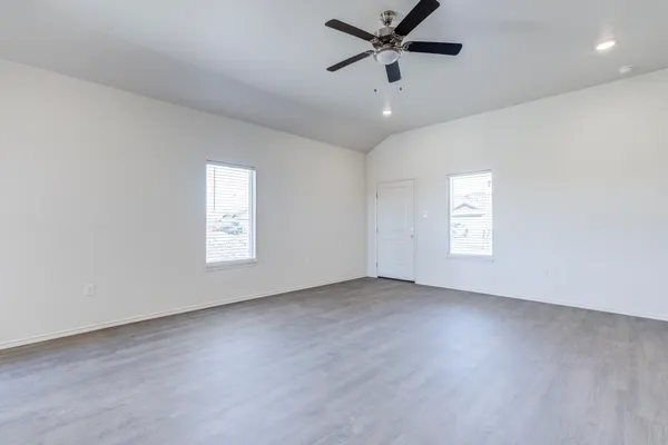 an empty room with a window and a fan