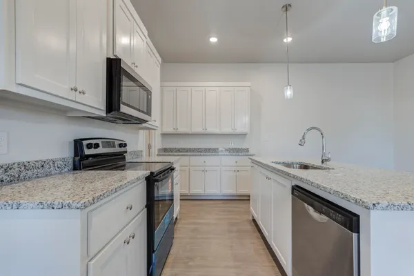 a kitchen with stainless steel appliances granite countertop a sink stove and cabinets