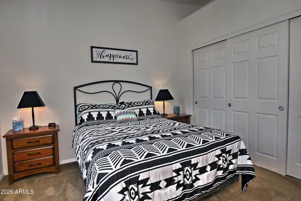 a bedroom with a bed a chandelier and a window