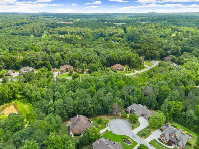 a view of a lush green forest with a house