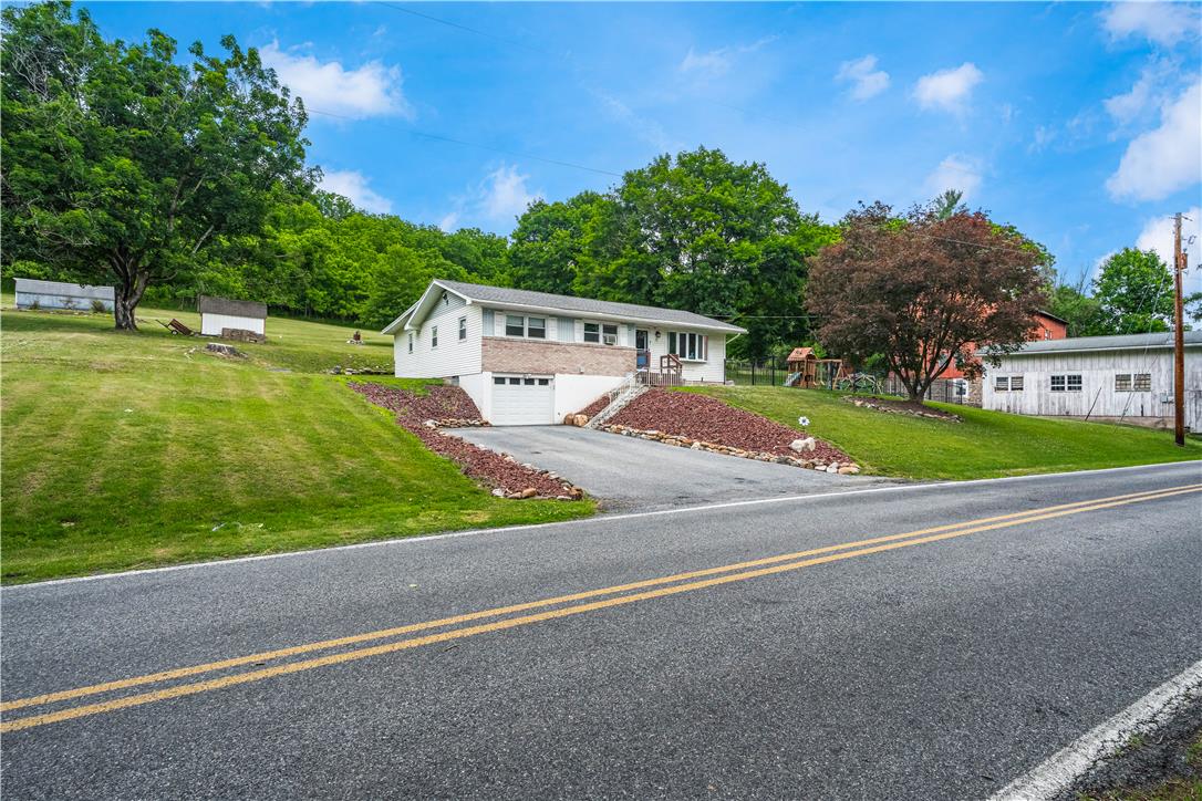 50 Kohls Road Northampton, PA 18067 - Photo 2 of 54 A well-maintained residence with an attached garage nestles into a verdant hillside, offering ample privacy and outdoor space.
