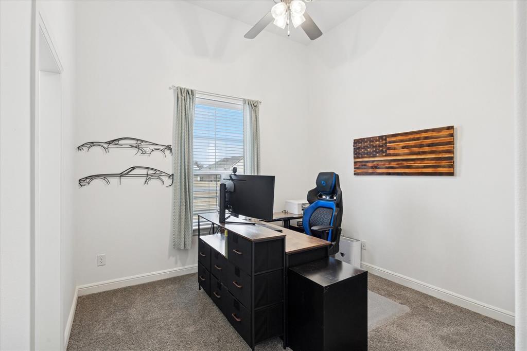 112 Friendship Way Boyd, TX 76023 - Photo 13 of 29 Bright interior space featuring a window with horizontal blinds and drapery, neutral carpet flooring, and a ceiling fan with integrated lighting