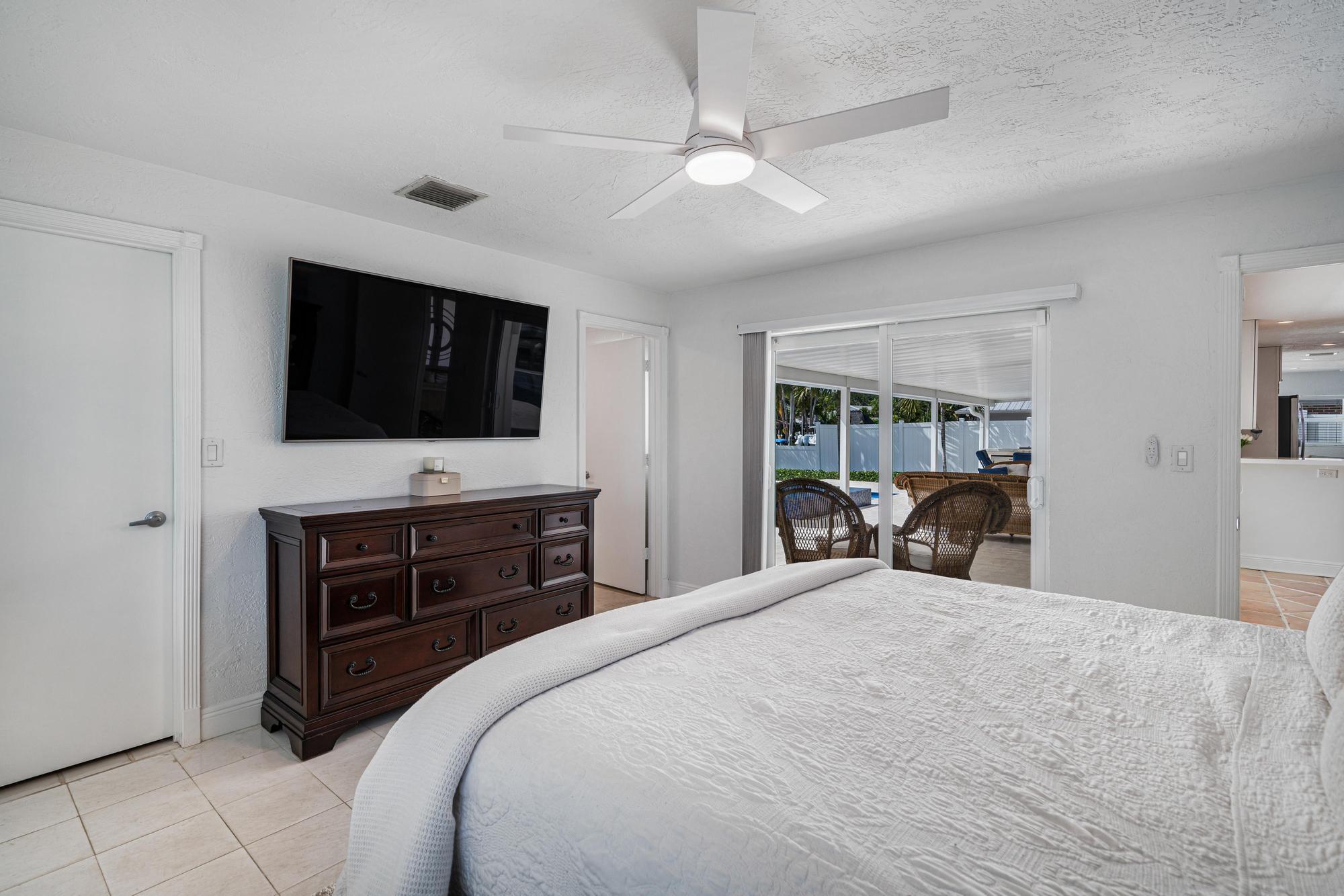 932 Marlin Circle Jupiter, FL 33458 - Photo 22 of 56 a large bedroom with a bed and a flat tv screen on dresser