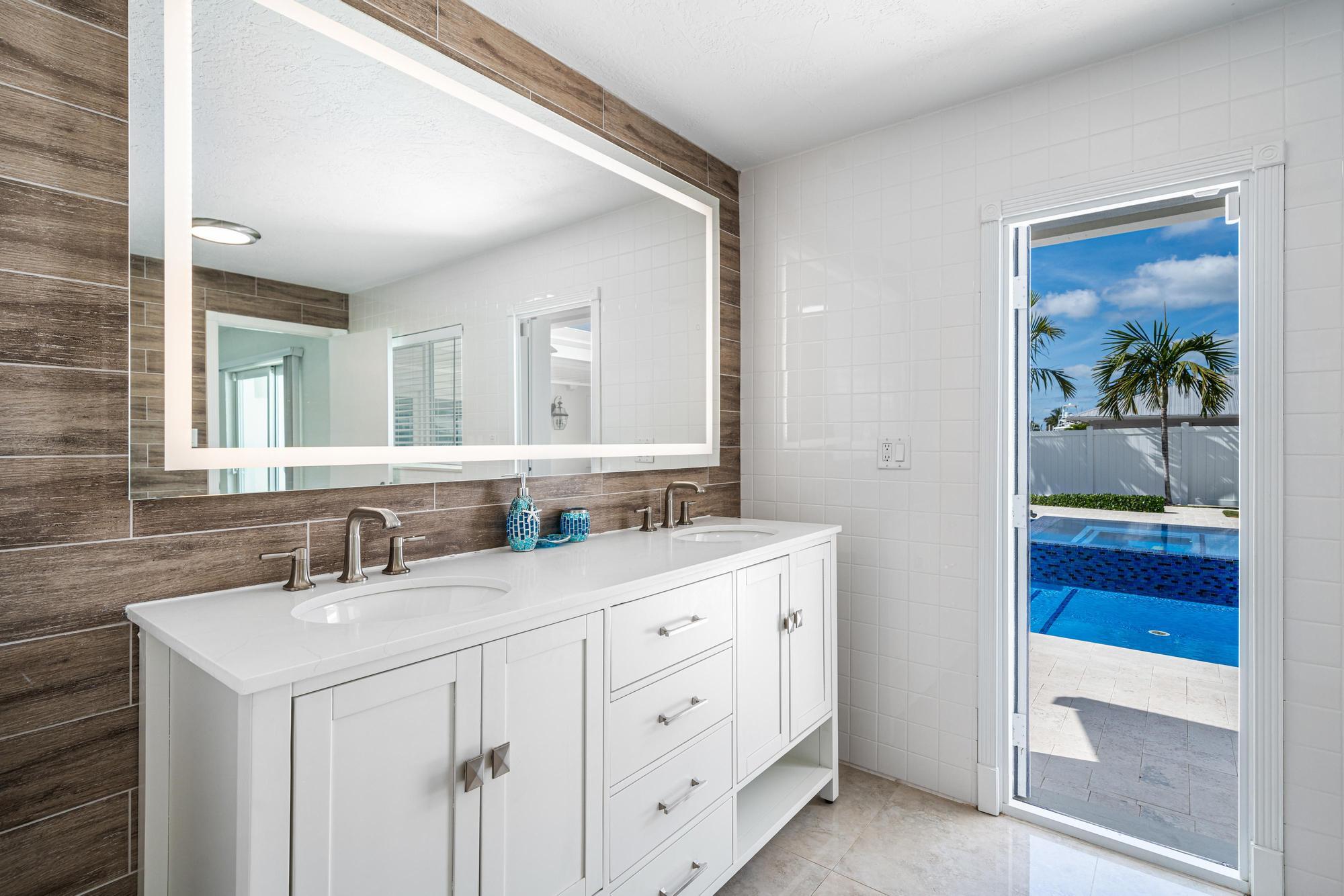 932 Marlin Circle Jupiter, FL 33458 - Photo 26 of 56 a bathroom with a double vanity sink and a mirror