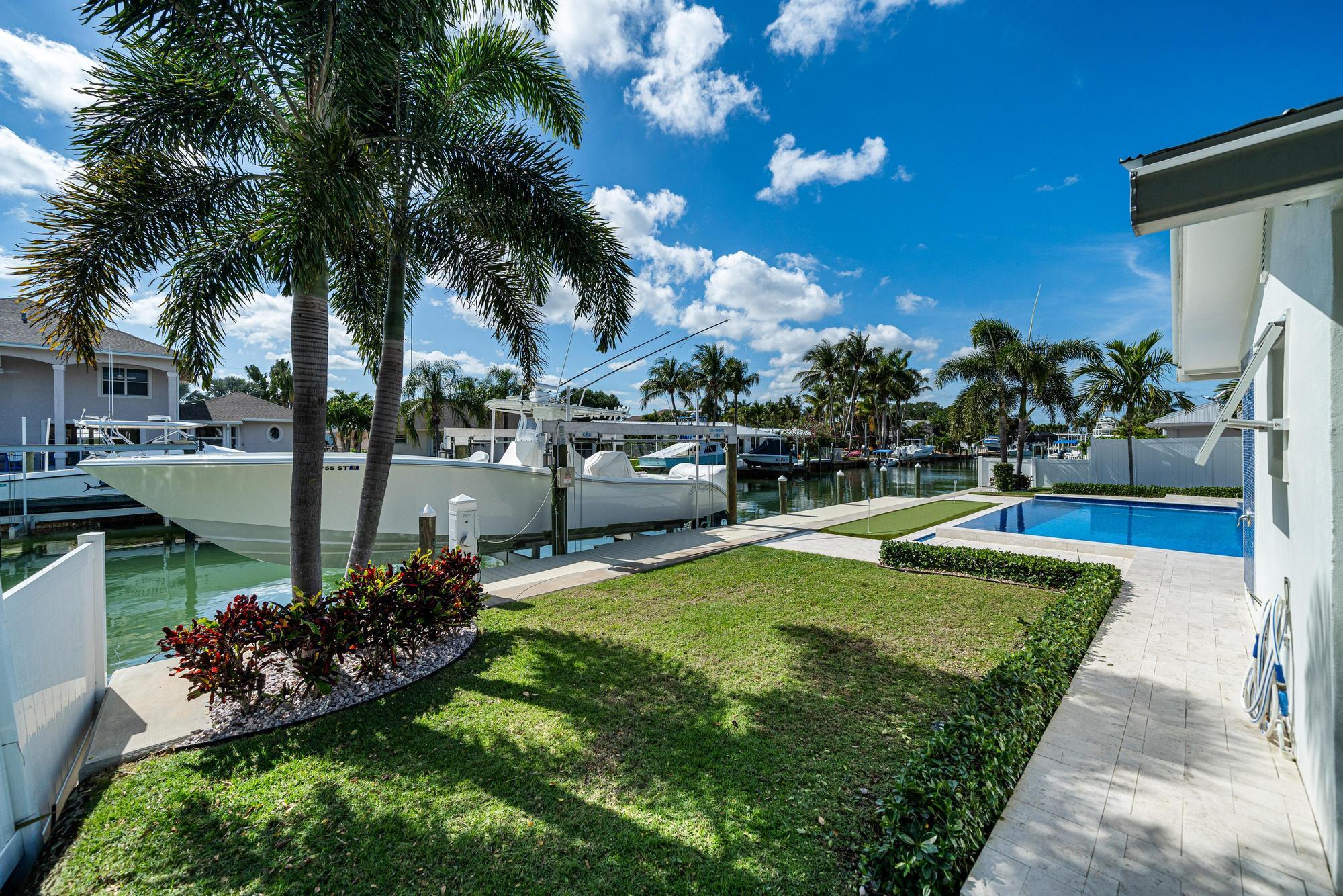 932 Marlin Circle Jupiter, FL 33458 - Photo 42 of 56 a view of a swimming pool with a patio and a garden