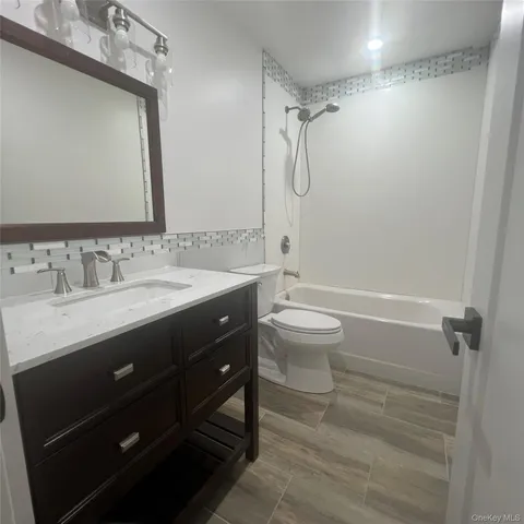 a bathroom with a double vanity sink toilet mirror and shower