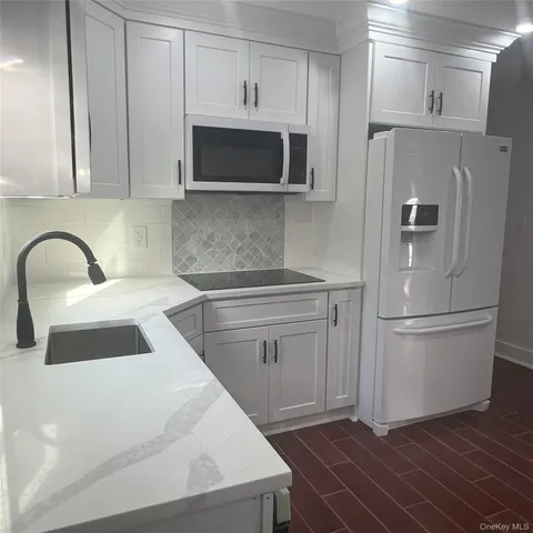 a kitchen with stainless steel appliances a refrigerator sink and microwave