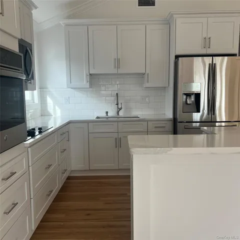 a kitchen with cabinets stainless steel appliances and sink