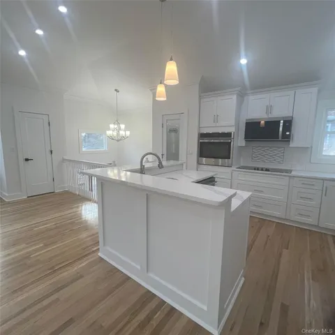 a large kitchen with kitchen island a sink stainless steel appliances and cabinets