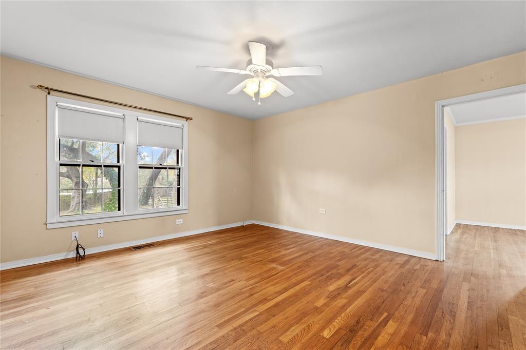 3808 North 27th Street Waco, TX 76708 - Photo 23 of 39 an empty room with wooden floor chandelier fan and windows