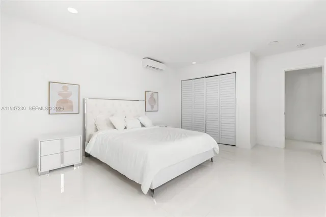 a large bed sitting in a bedroom next to a bathroom