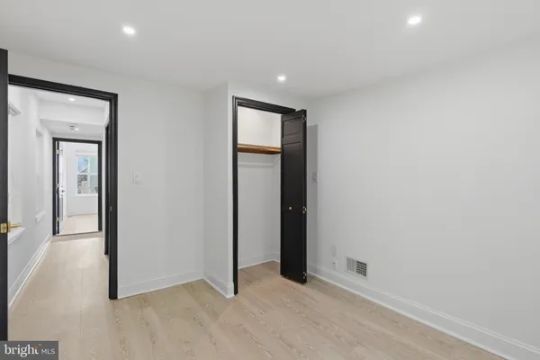 an empty room with closet and mirror