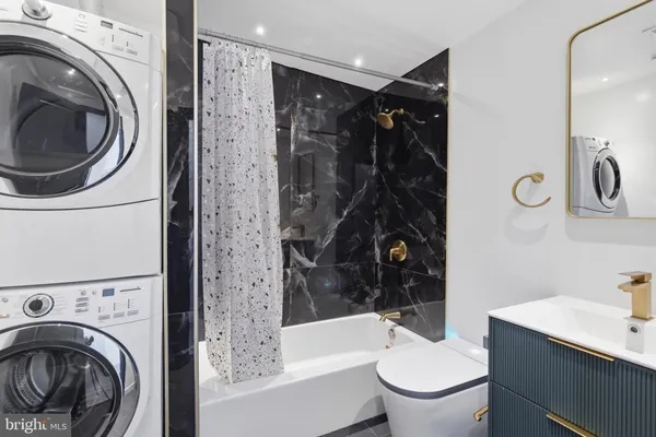 a bathroom with a bathtub sink mirror and toilet