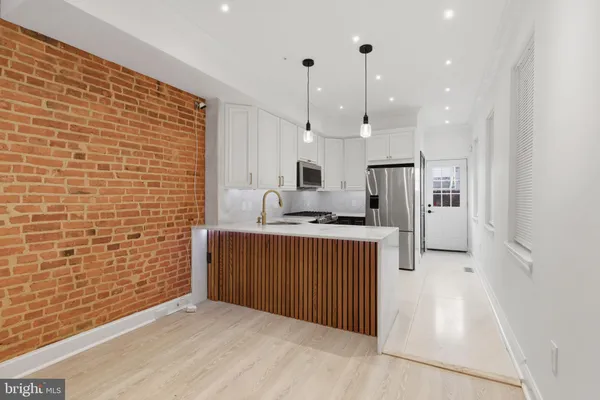 a kitchen with stainless steel appliances granite countertop a refrigerator and a sink