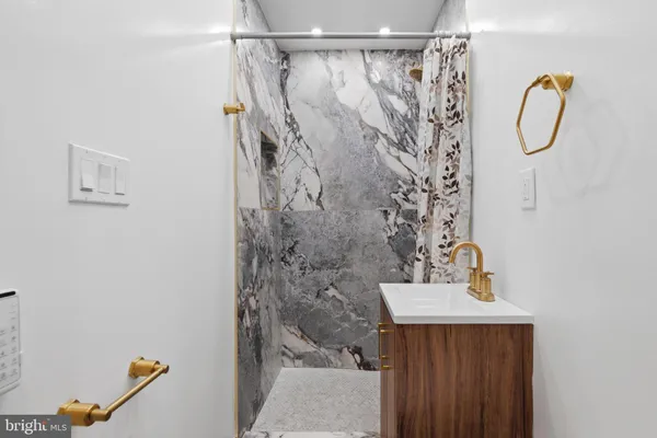 a bathroom with a sink mirror and shower