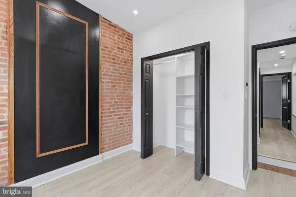 a view of a hallway with wooden floor and closet