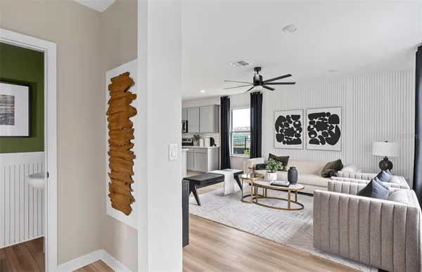 a living room with furniture kitchen view and a chandelier