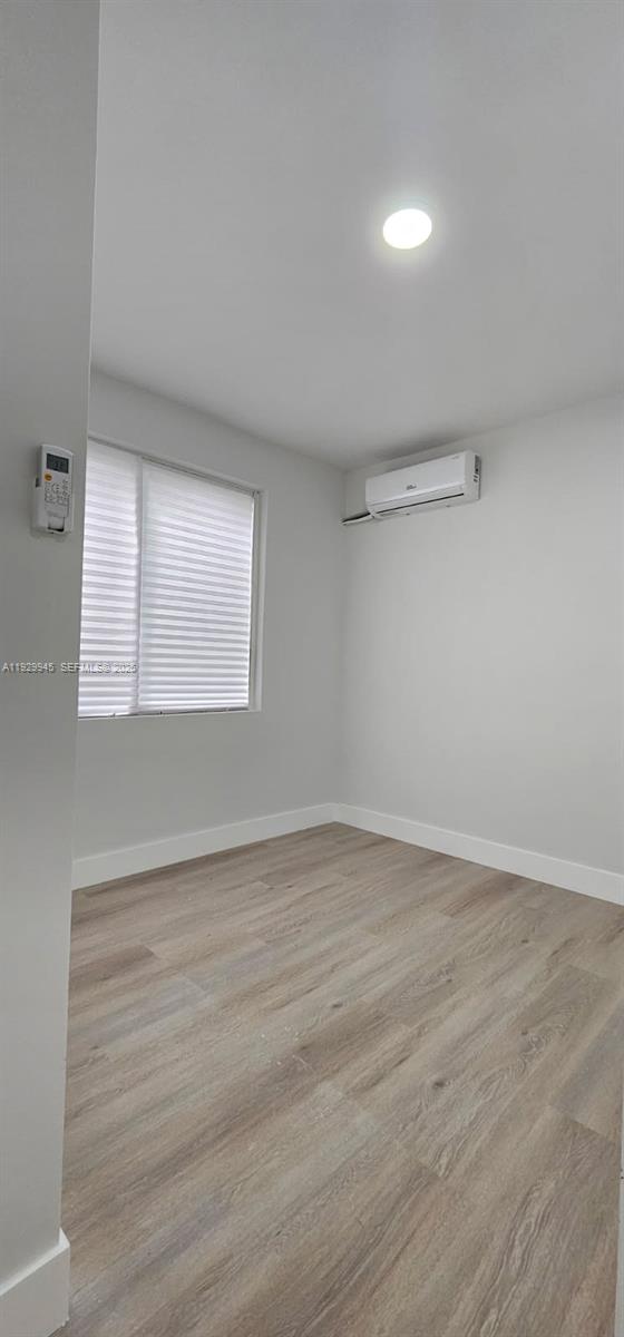2425 Southwest 6th Street, Unit 4 Miami, FL 33135 - Photo 8 of 14 a view of an empty room with wooden floor and a window
