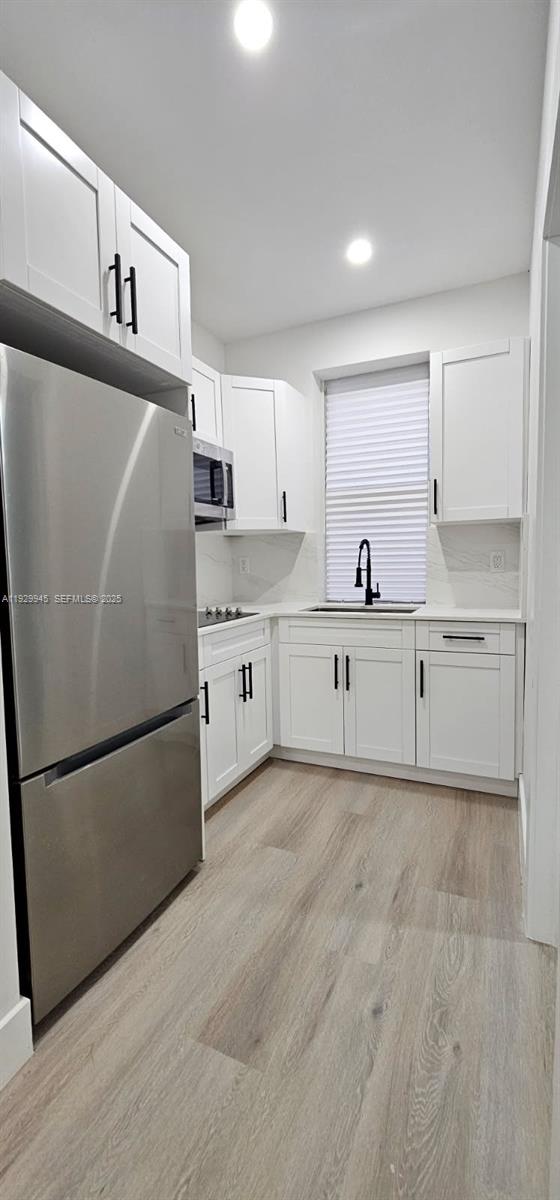 2425 Southwest 6th Street, Unit 4 Miami, FL 33135 - Photo 10 of 14 a kitchen with stainless steel appliances granite countertop a refrigerator sink and white cabinets