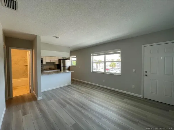 a view of a living hall with wooden floor and a window