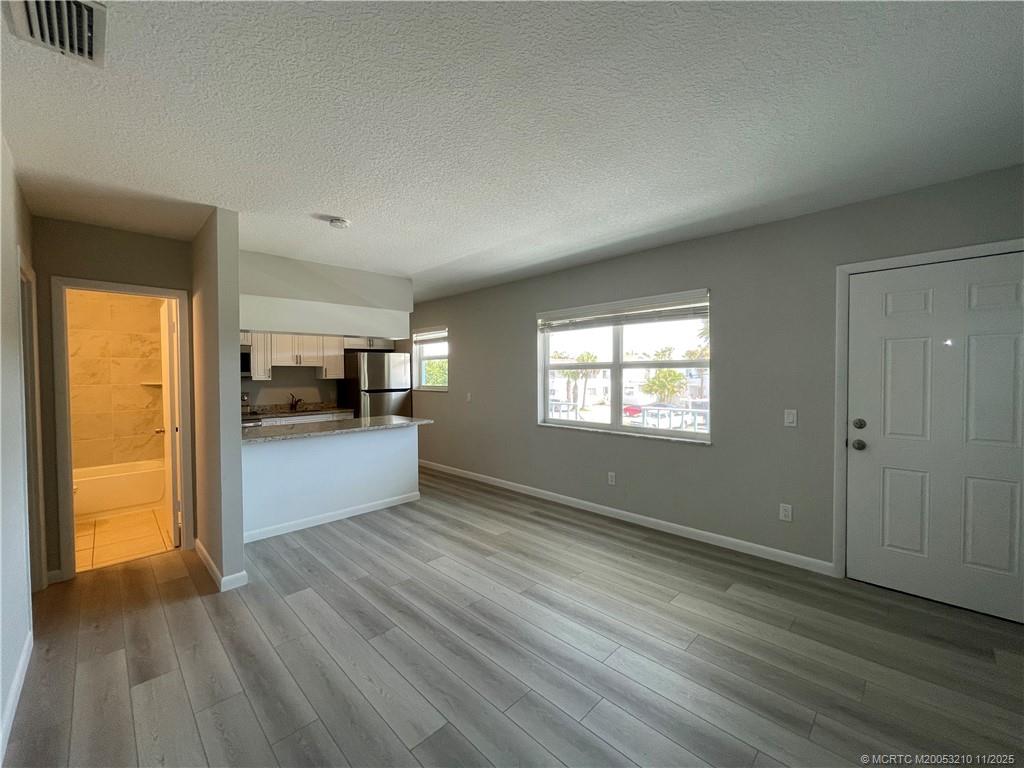 661 Hernando Street, Unit 9 Fort Pierce, FL 34949 - Photo 2 of 10 a view of a living hall with wooden floor and a window