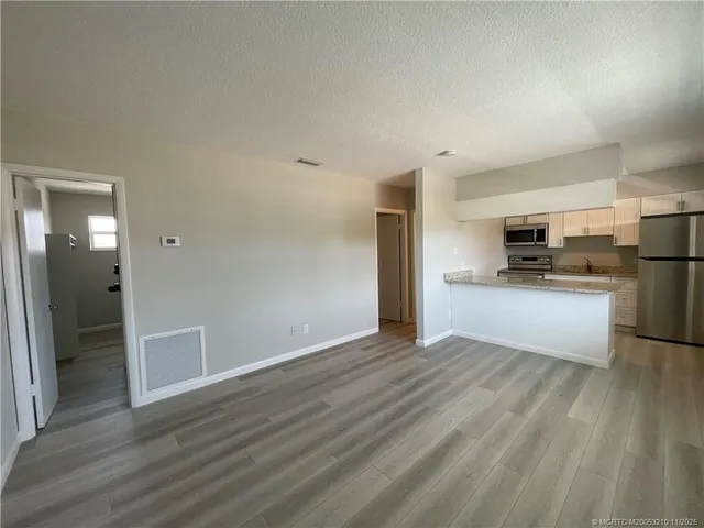 a view of kitchen with wooden floor electronic appliances and window
