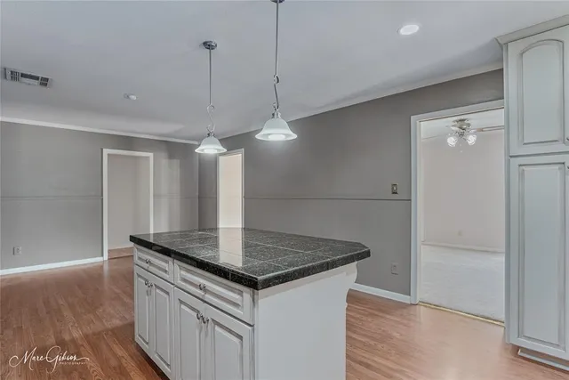 a kitchen with stainless steel appliances granite countertop a sink a refrigerator a counter space and wooden floor