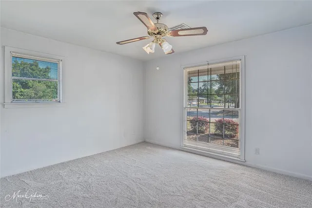 an empty room with fan and windows