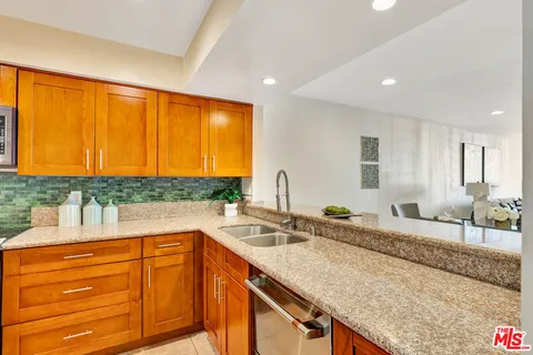 a kitchen with granite countertop counter top space a sink stainless steel appliances and cabinets