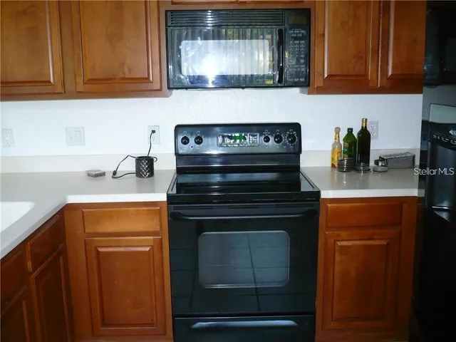 a kitchen with stainless steel appliances granite countertop a stove microwave and cabinets