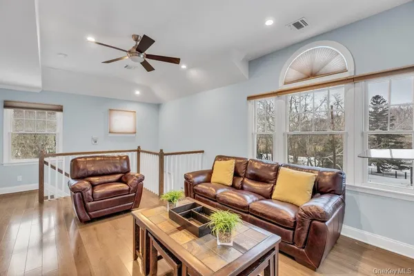 a living room with furniture a ceiling fan and a flat screen tv