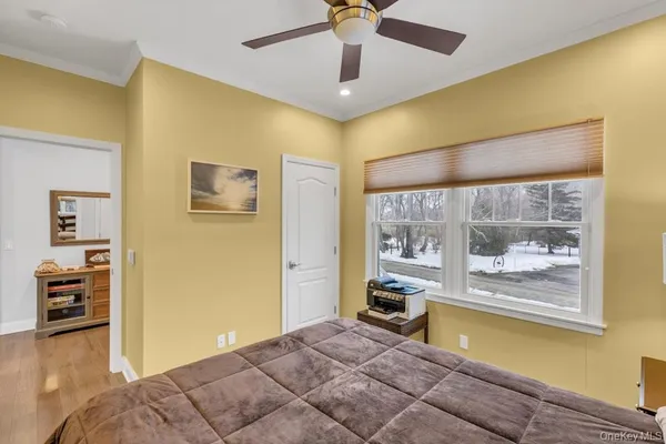 a spacious bedroom with a bed and wooden floor