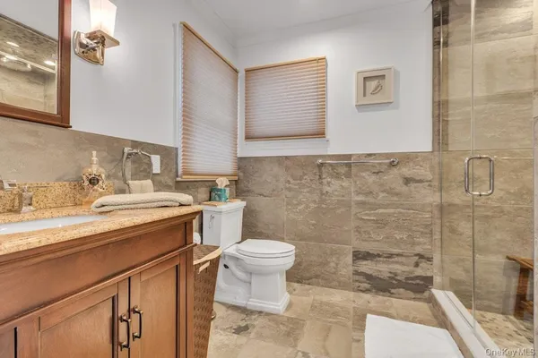 a bathroom with a granite countertop sink mirror vanity and toilet