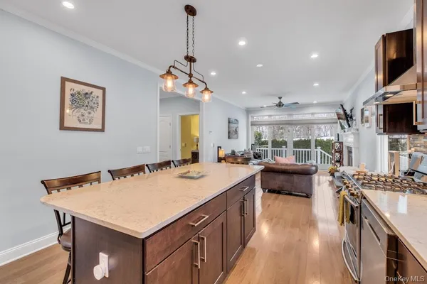 a kitchen with a stove a kitchen island a sink and a living room with furniture