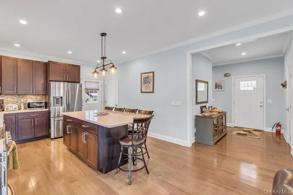 a kitchen with a stove a kitchen island a sink and a living room with furniture