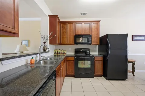 a kitchen with stainless steel appliances granite countertop a refrigerator stove top oven and sink